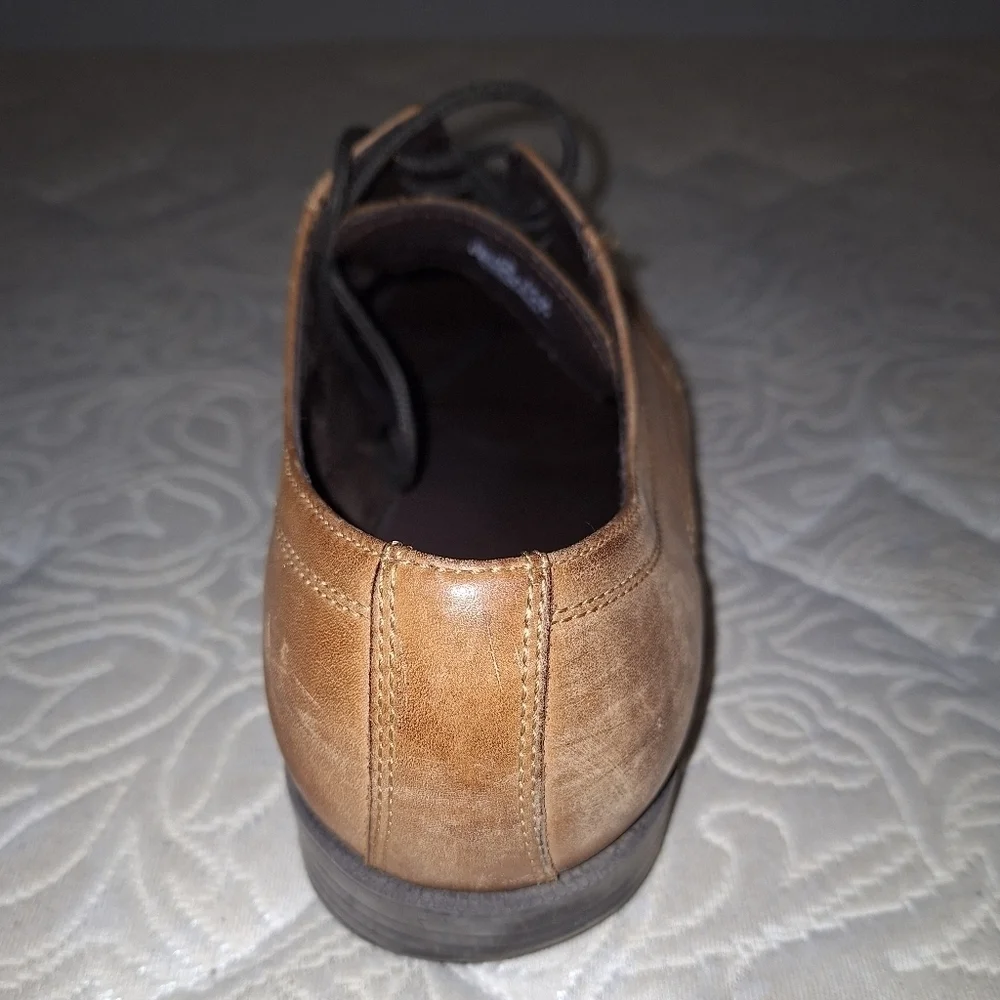 A pair of Cole Haan Oxfords in a men's size 12M. Pre-loved in good condition.